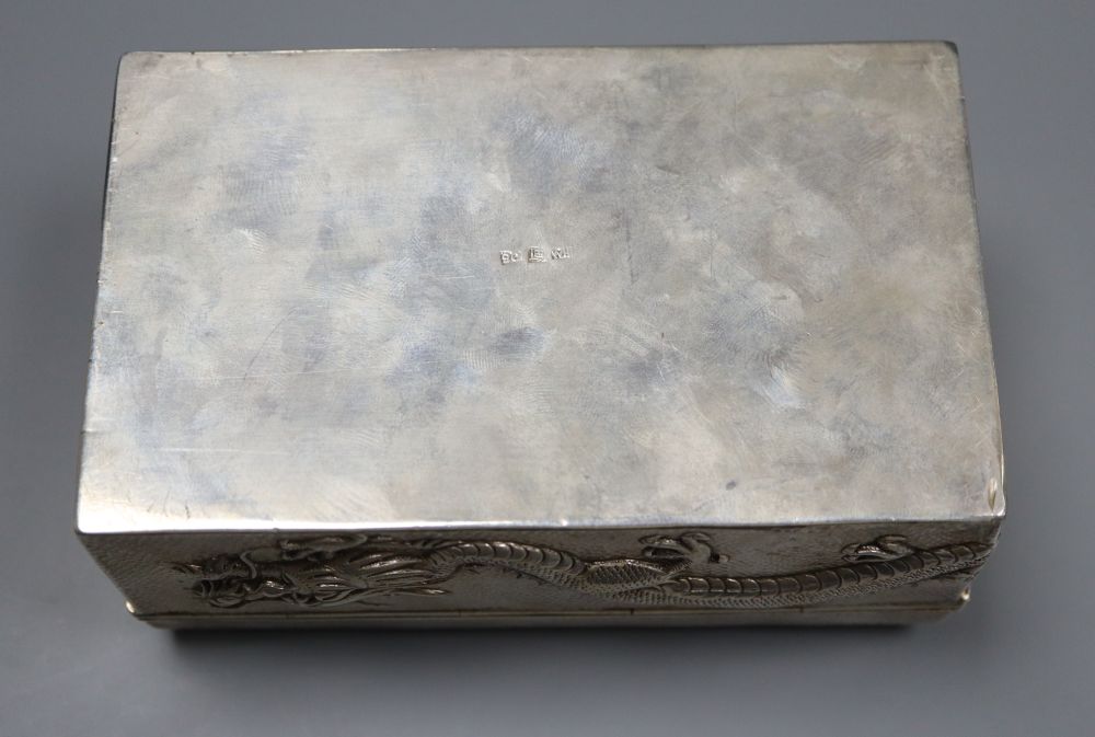 An early 20th century Chinese Export white metal cigarette box, embossed with a dragon, by Wang Hing, 13cm, gross 9oz.